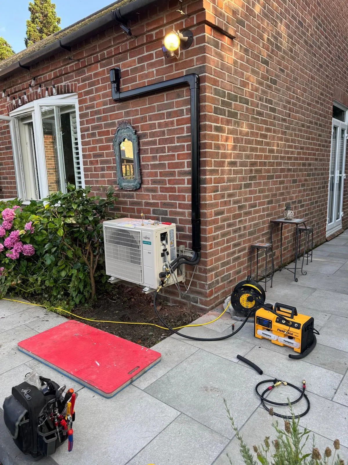 Fujitsu air-conditioning outdoor unit mounted on brickwork